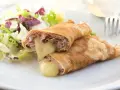 Herzhafte Pfannkuchen gefüllt mit Schinken und geschmolzenem Käse, serviert mit einem frischen Salat.