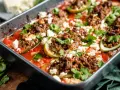 Gefüllte Zucchini mit Hackfleisch und Feta in Tomatensauce, ein köstliches Gericht, das zeigt, wie vielseitig Rezepte mit Gurken sein können.