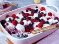 Cremiger Windbeutel-Dessert-Auflauf mit frischen Beeren wie Himbeeren, Blaubeeren und Brombeeren.