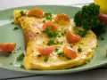 Ein goldgelbes Omelett, garniert mit Kirschtomaten und Petersilie. Ein einfaches und leckeres Omelett Rezept für jeden Tag.
