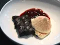 Schokoladenbrownie mit Fruchtsauce und einer perfekt hergestellten, luftigen Espuma, bestäubt mit Kakao.