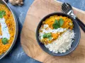 Herzhafte Linsen Rezepte: Cremiges Dal mit Reis, garniert mit Koriander und Kokosmilch. Ein köstliches Gericht, das Wärme und Geschmack vereint.