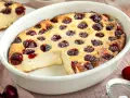Ein goldbrauner Kirschauflauf mit Puderzucker bestäubt, bereit zum Servieren. Dieses Kirschauflauf Rezept ist ein Genuss!