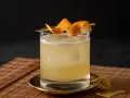 Klassisches Rezept für Gin Tonic: Ein erfrischender Drink mit Eis, garniert mit Orangenschale.