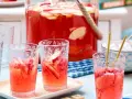 Erfrischende alkoholfreie Bowle mit Apfelstücken in Gläsern, bereit für ein sommerliches Treffen.