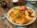 Goldbraunes Schnitzel, perfekt paniert, mit Rosmarinkartoffeln und Zitrone. Die richtige **Schnitzel panieren Reihenfolge** macht's möglich!