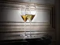 Zwei elegante Gläser, eines wird mit Champagner gefüllt. So trinkt man Champagner stilvoll.