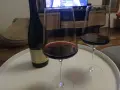 Zwei Gläser Rotwein und eine Flasche Wein, die an die Beaujolais-Region erinnert, stehen auf einem weißen Tablett.