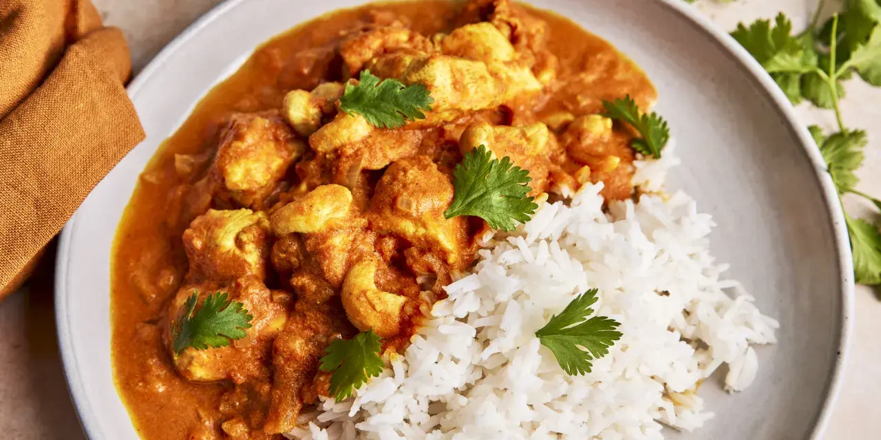 Cremiges Chicken Korma mit Basmatireis und frischem Koriander. Ein köstliches indisches Gericht, das zum Genießen einlädt.