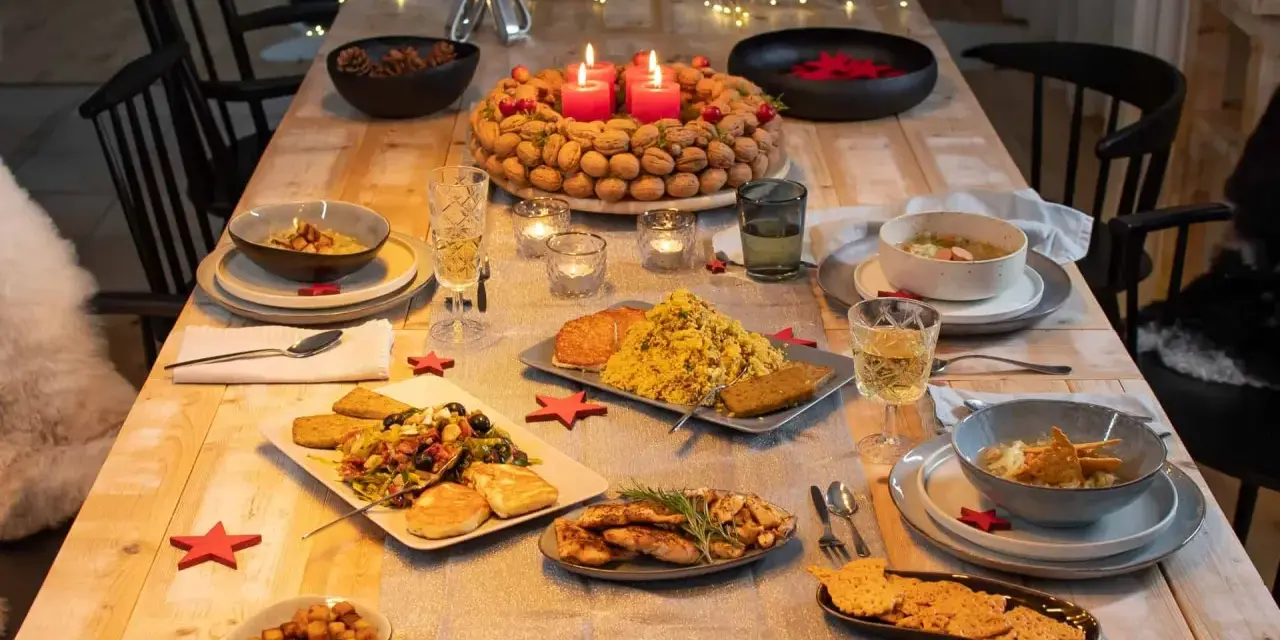 Festlich gedeckter Tisch mit vielen Speisen, Kerzen und Sternen. Perfekt, um das weihnachtsessen einen tag vorher vorbereiten zu können.