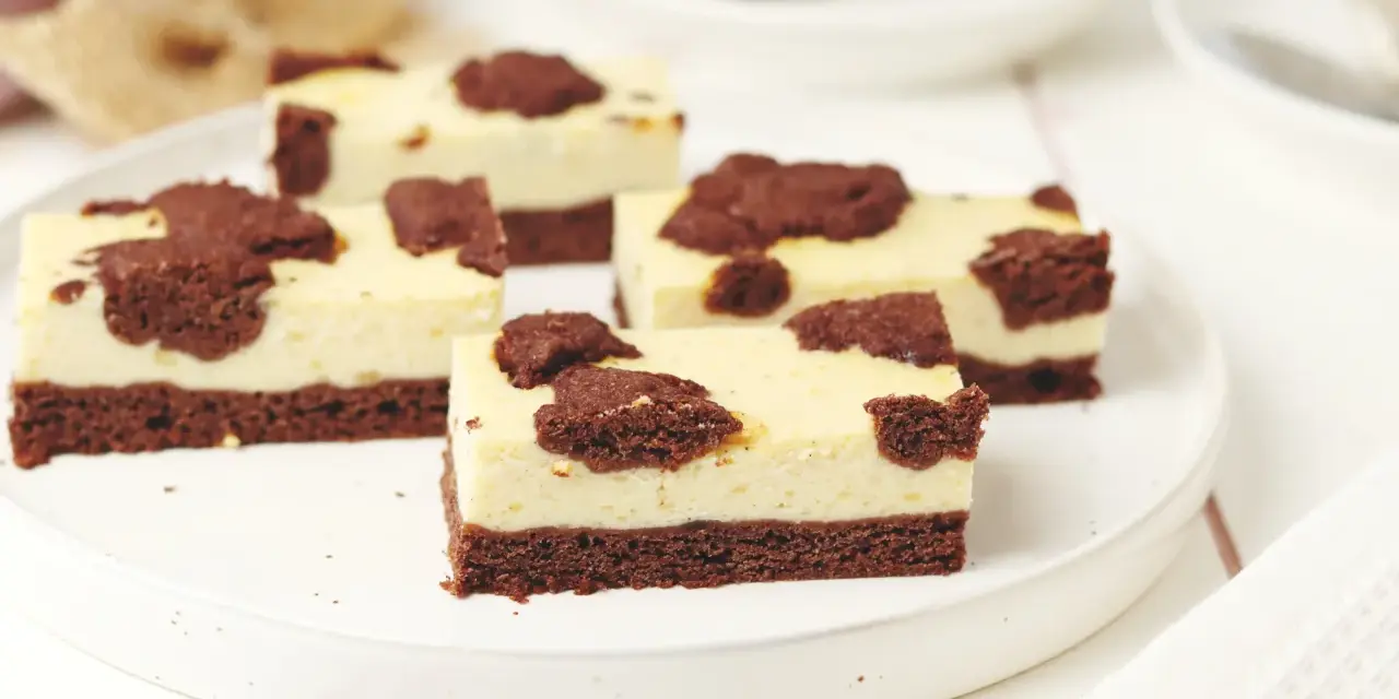 Saftiger russischer Zupfkuchen vom Blech, in Stücke geschnitten, mit Schokoladenstückchen auf cremiger Käsemasse.