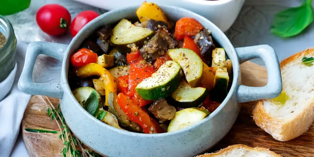 Herzhaftes Ratatouille mit Zucchini, Aubergine und Paprika, serviert in einer Schüssel mit Brot. Perfekt für Ratatouille Rezepte.