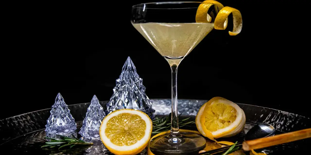 Ein eleganter French 75 Cocktail mit Zitronenzeste, dekoriert mit Kristallbäumen und Rosmarin.