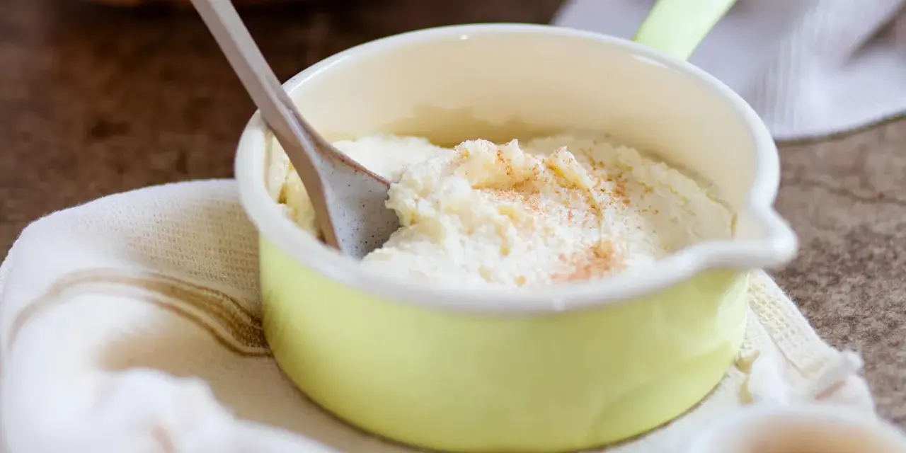 Cremiger Grießbrei, perfekt für ein schnelles Grießbrei Rezept, bestreut mit Zimt in einer kleinen gelben Schüssel.