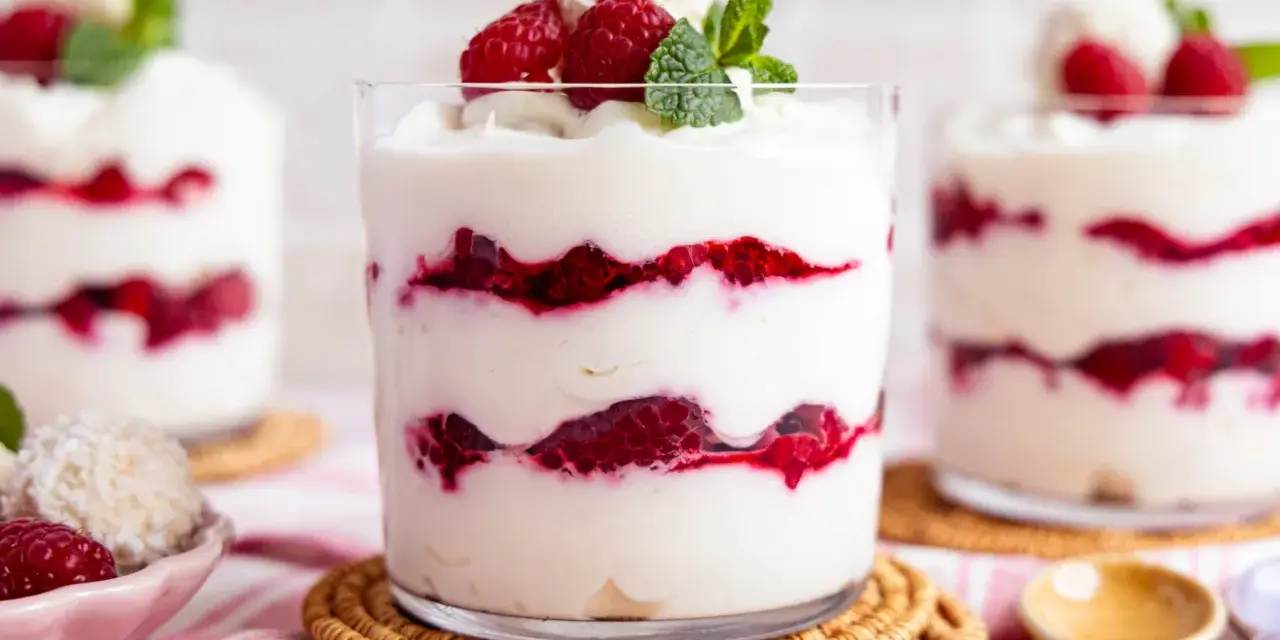 Schichtdessert mit Himbeeren und Kokosflocken, das an Raffaello Creme erinnert.