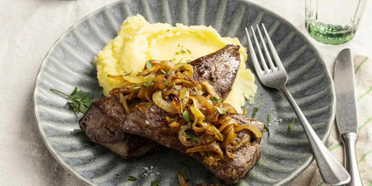 Leber braten mit karamellisierten Zwiebeln und Kartoffelpüree auf einem grauen Teller. Ein Klassiker, der immer schmeckt.