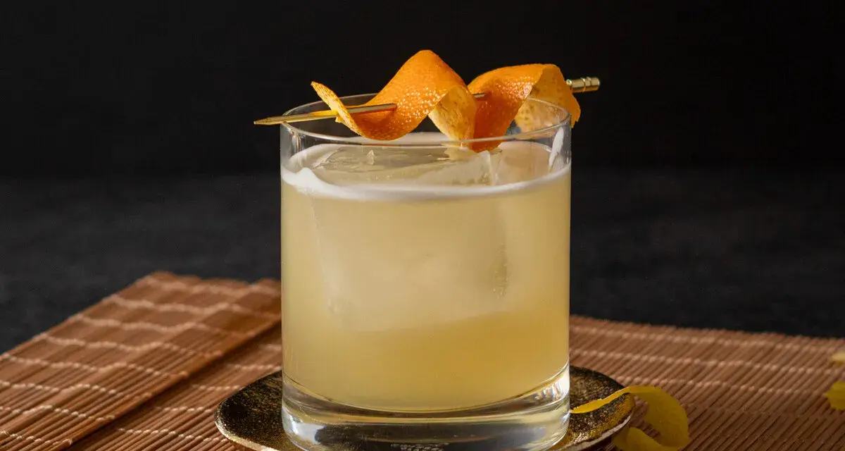 Klassisches Rezept für Gin Tonic: Ein erfrischender Drink mit Eis, garniert mit Orangenschale.