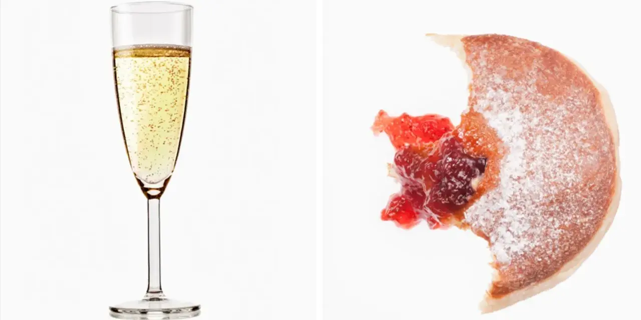 Sektglas mit Bläschen und ein angebissener Krapfen mit Marmelade. Wein Kalorien sind oft unterschätzt.