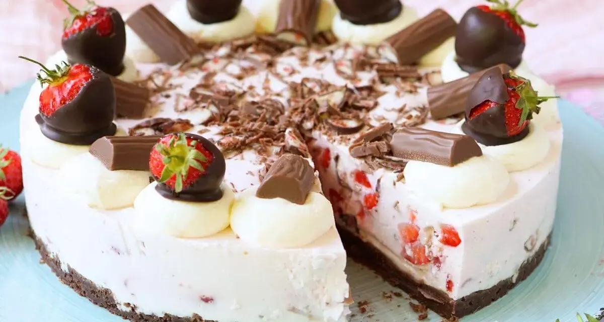 Eine köstliche Yogurette Torte mit frischen Erdbeeren, Schokostückchen und Sahnetupfern. Ein Genuss für alle Sinne!