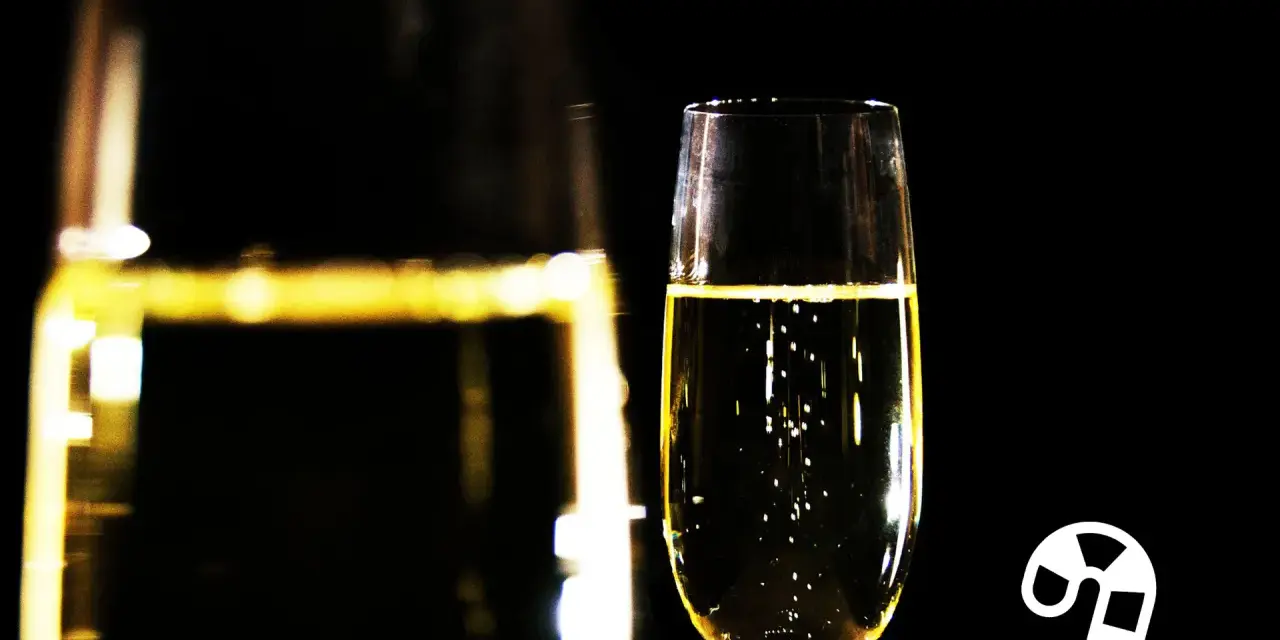 Ein Glas Champagner mit Bläschen, daneben ein Zuckerstangen-Symbol. Die richtige dosage Champagner für den festlichen Anlass.