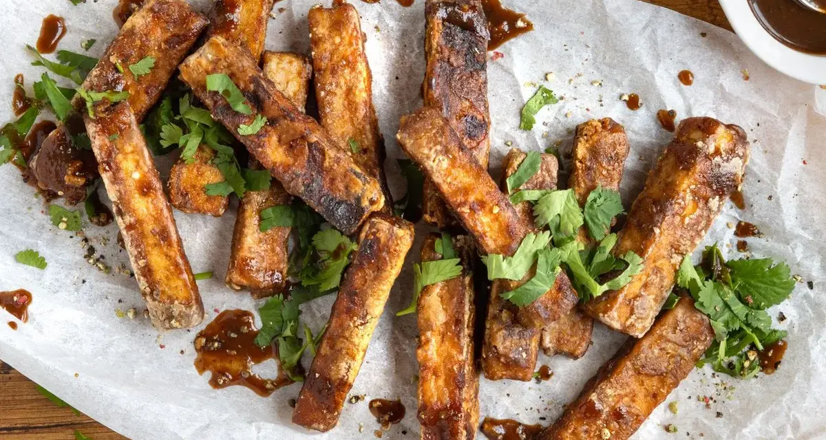 Marinierter Tofu, knusprig gebraten und mit frischem Koriander und einer dunklen Sauce garniert. Perfekt zum **Tofu marinieren** und Genießen.