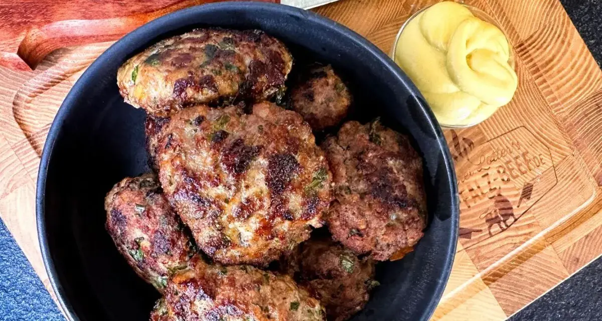 Leckeres Buletten Rezept: Saftige Frikadellen in einer Schüssel, daneben Senf und ein Messer. Perfekt für den Grill oder die Pfanne.