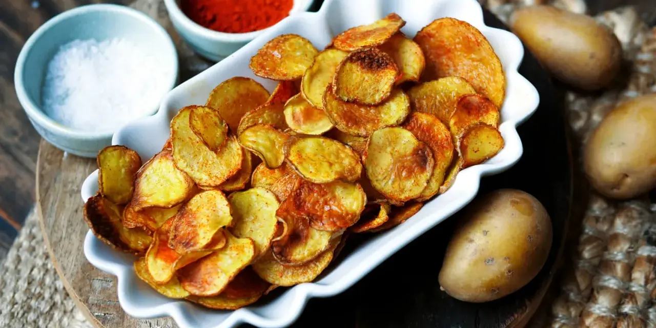 Selbstgemachte Kartoffelchips, goldbraun und knusprig, mit Salz und Paprikapulver. So einfach ist kartoffelchips selber machen!