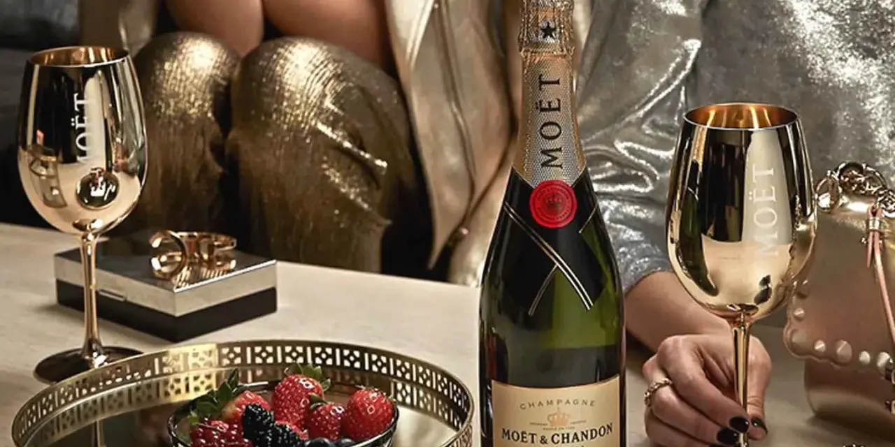 Elegante Szene mit Moët & Chandon Champagnerflasche, goldenen Gläsern und Beeren. Die Herkunft des Luxus wird durch die Marke und die festliche Atmosphäre betont.