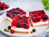 Drei Stücke einer erfrischenden sommertorte mit Beeren und Gelee auf einem Teller.