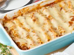 Überbackene Cannelloni mit geschmolzenem Käse in einer blauen Auflaufform, ein köstliches Cannelloni Rezept.