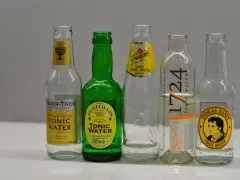 Fünf Flaschen Tonic Water: Fever-Tree, Fentimans, Schweppes, 1724 und Thomas Henry. Sie zeigen, nach was Tonic Water schmeckt: herb-bitter, erfrischend, mit Zitrus- und Kräuternoten.