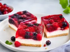 Drei Stücke einer erfrischenden sommertorte mit Beeren und Gelee auf einem Teller.
