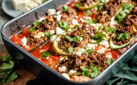 Gefüllte Zucchini mit Hackfleisch und Feta in Tomatensauce, ein köstliches Gericht, das zeigt, wie vielseitig Rezepte mit Gurken sein können.