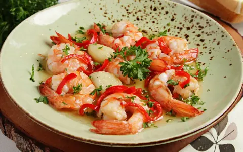 Garnelen in Knoblauchöl mit Paprika und Petersilie, ein köstliches Gericht, das perfekt zu einem Glas Wein passt.
