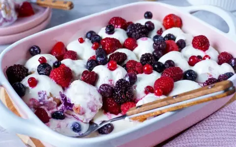 Cremiger Windbeutel-Dessert-Auflauf mit frischen Beeren wie Himbeeren, Blaubeeren und Brombeeren.
