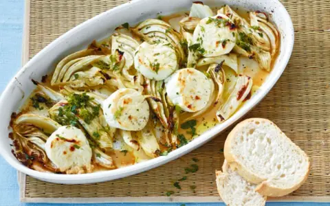 Überbackener Fenchel mit Ziegenkäse, ein köstliches Fenchel Rezept, garniert mit Petersilie und serviert mit Brot.