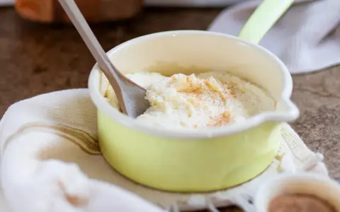 Cremiger Grießbrei, perfekt für ein schnelles Grießbrei Rezept, bestreut mit Zimt in einer kleinen gelben Schüssel.