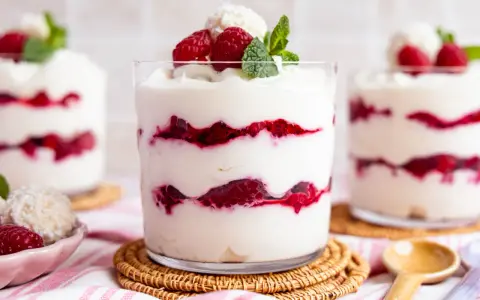Schichtdessert mit Himbeeren und Kokosflocken, das an Raffaello Creme erinnert.