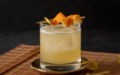 Klassisches Rezept für Gin Tonic: Ein erfrischender Drink mit Eis, garniert mit Orangenschale.