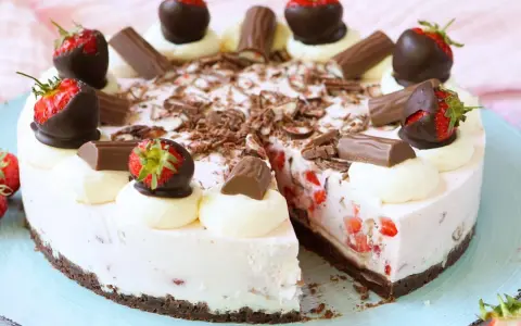 Eine köstliche Yogurette Torte mit frischen Erdbeeren, Schokostückchen und Sahnetupfern. Ein Genuss für alle Sinne!
