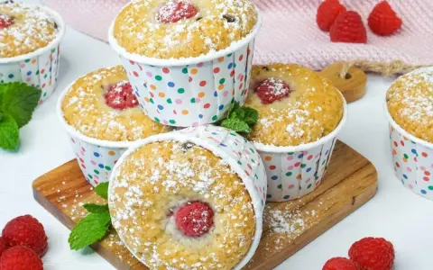 Leckere Muffins mit Himbeeren, bestäubt mit Puderzucker. Perfekt zum ei ersatz backen und Genießen.