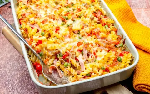 Ein köstlicher, schneller Auflauf ohne Vorkochen mit Nudeln, Schinken, Erbsen und Paprika, überbacken mit Käse.