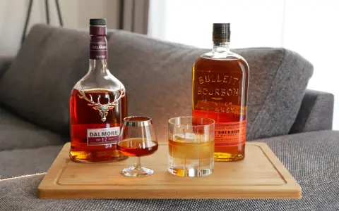 Zwei Flaschen und Gläser mit Whiskey zeigen die whiskey sorten unterschiede: ein Dalmore Scotch und ein Bulleit Bourbon.