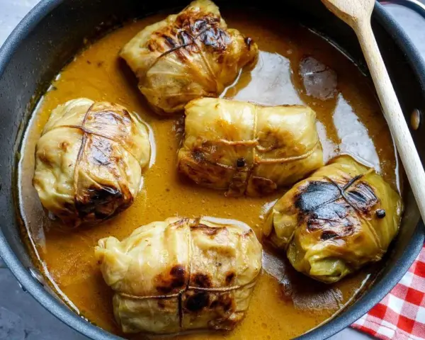 Fünf Kohlrouladen im Topf, bereit für ein köstliches Kohlrouladen Rezept.