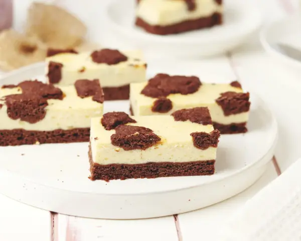 Saftiger russischer Zupfkuchen vom Blech, in Stücke geschnitten, mit Schokoladenstückchen auf cremiger Käsemasse.