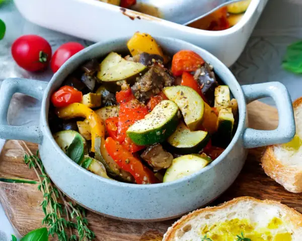 Herzhaftes Ratatouille mit Zucchini, Aubergine und Paprika, serviert in einer Schüssel mit Brot. Perfekt für Ratatouille Rezepte.