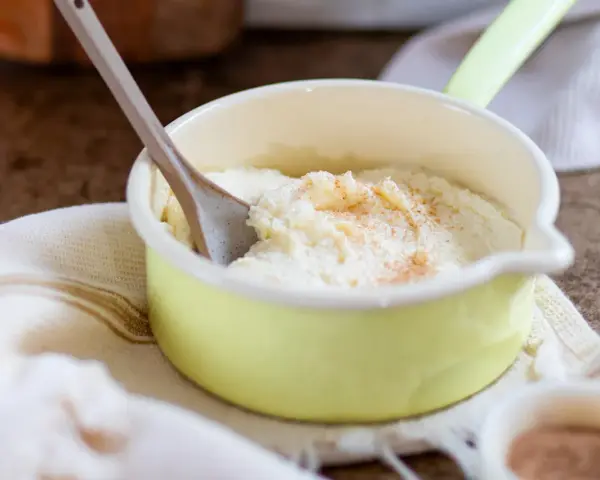 Cremiger Grießbrei, perfekt für ein schnelles Grießbrei Rezept, bestreut mit Zimt in einer kleinen gelben Schüssel.