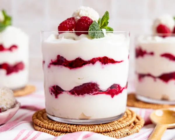 Schichtdessert mit Himbeeren und Kokosflocken, das an Raffaello Creme erinnert.