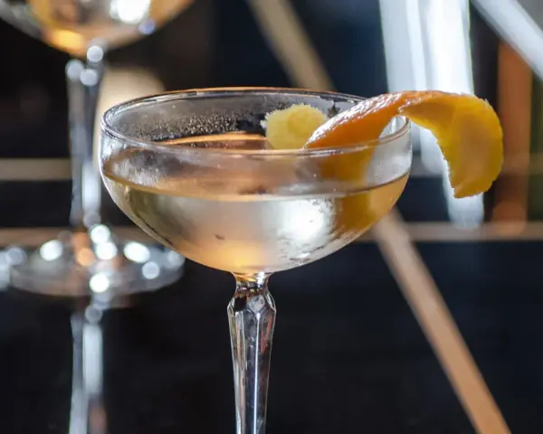 Ein klassischer James Bond Vesper Martini, garniert mit einer Zitronenzeste, in einem eleganten Glas.