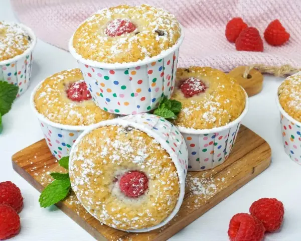 Leckere Muffins mit Himbeeren, bestäubt mit Puderzucker. Perfekt zum ei ersatz backen und Genießen.